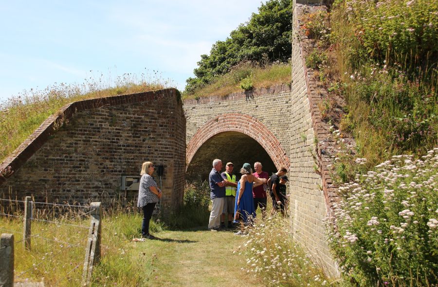 A group of seven people next to a brick arch