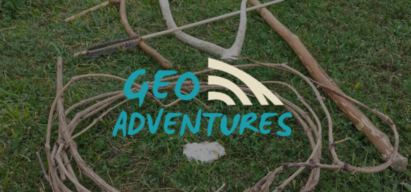 Pieces of wood laid on grass with GeoAdventures logo.