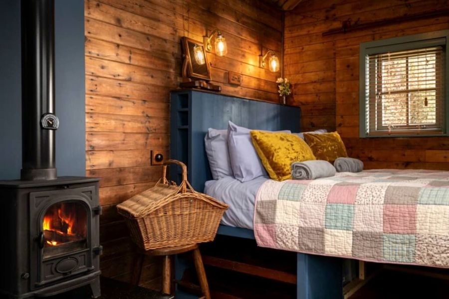 Sleeping area with double bed and log burner