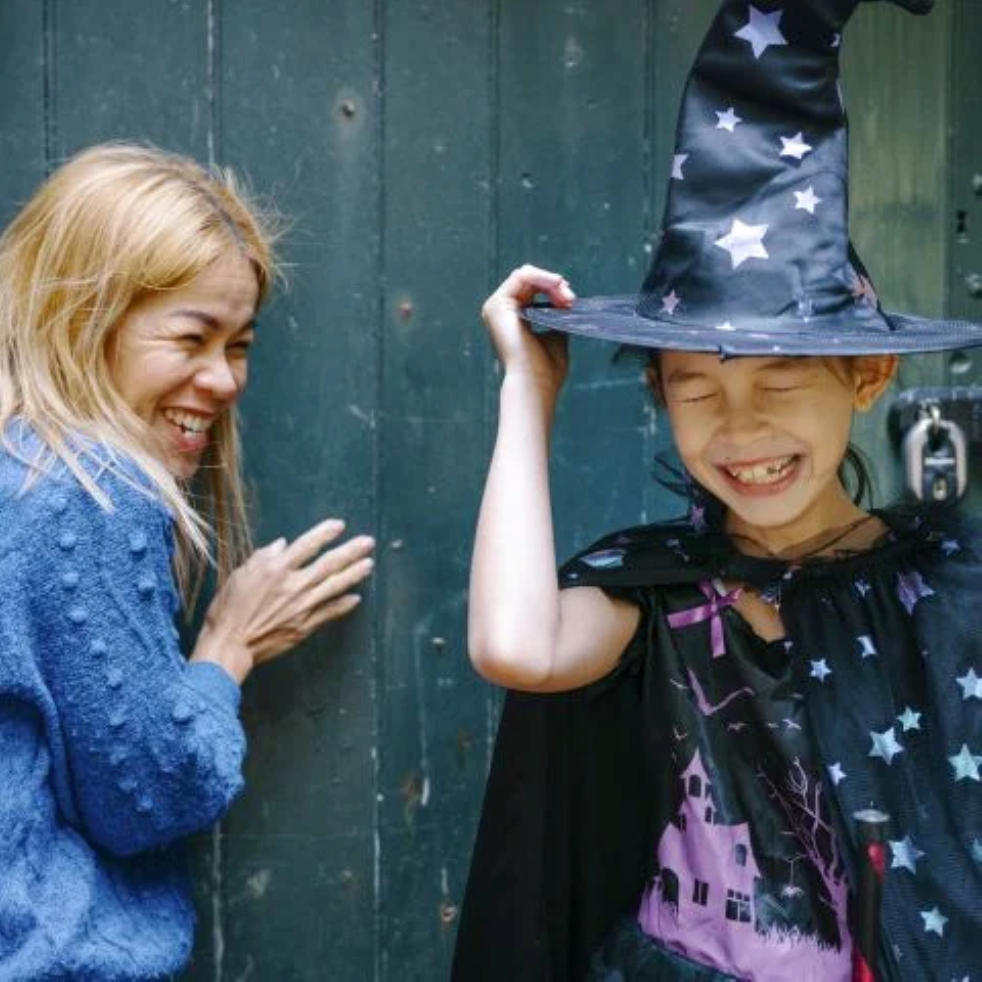 A girl dressed as a witch giggling with a lady