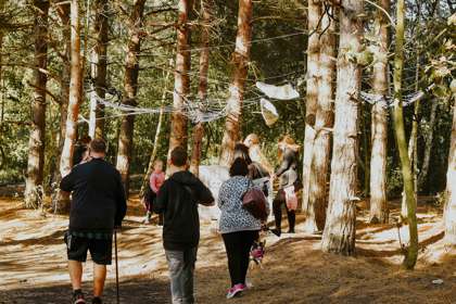 People walking through woodland for Halloween Trail at Betteshanger Park