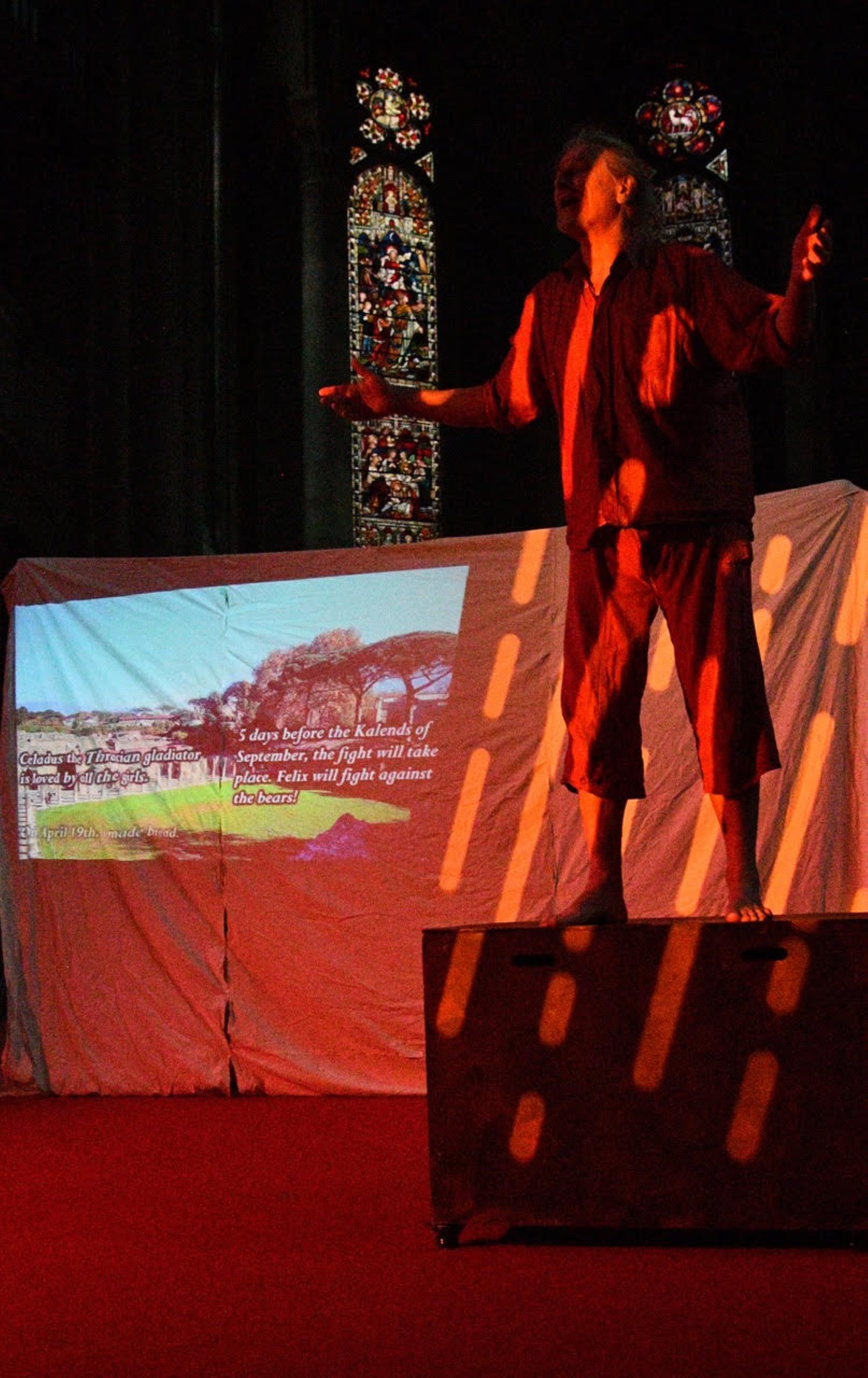 Character standing on a box with theatre lights shining on him