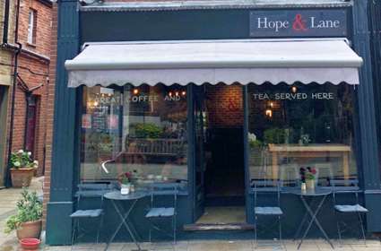 Exterior of the Hope & Lane with bistro tables and chairs.