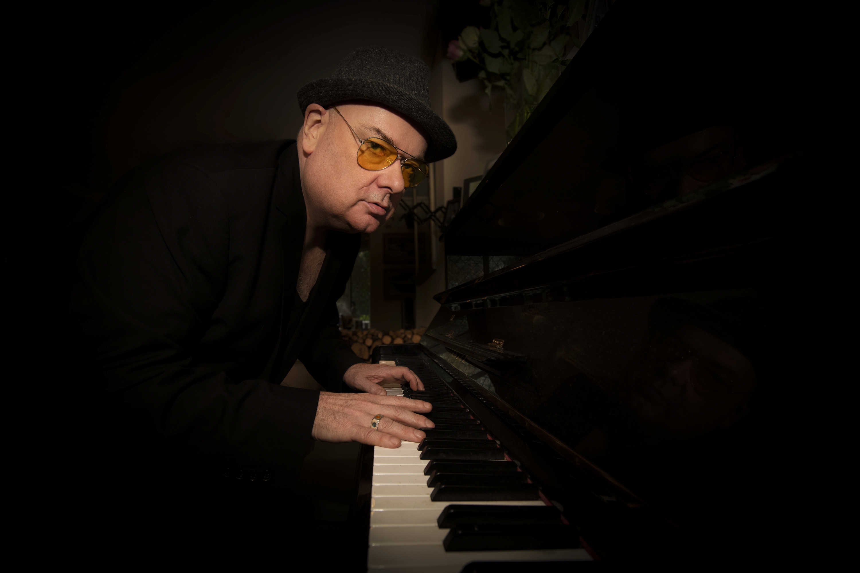 Dark photo of Ian playing a piano
