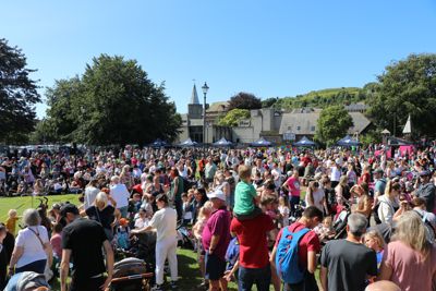 A crowd of people of all ages  in sunny Pencester Gardens, Dover.