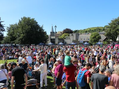 A crowd of people of all ages  in sunny Pencester Gardens, Dover.