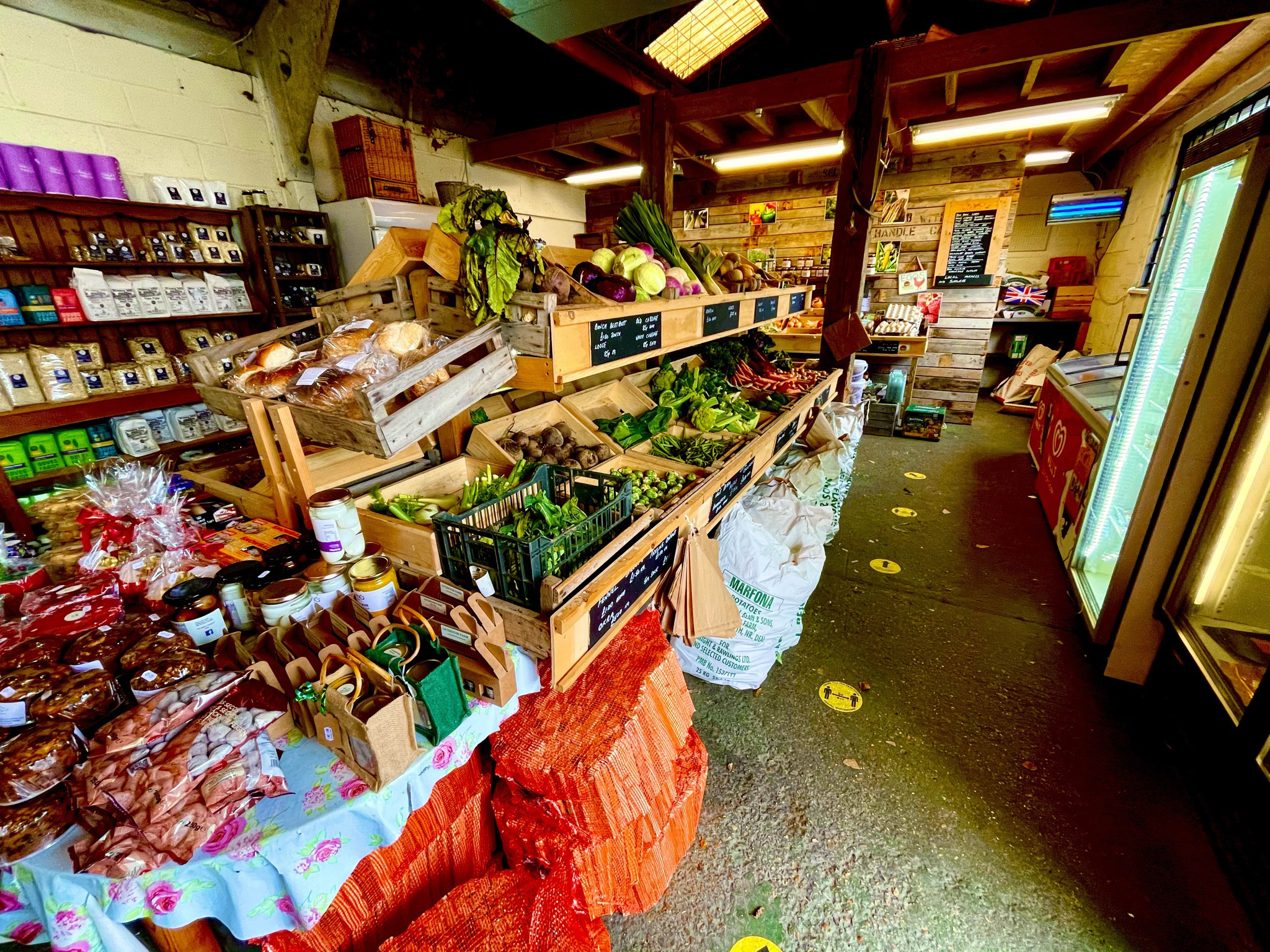 Inside of the shop showing a range of fresh fruit and vegetable as well local produce in jars and packaging.