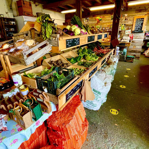 Inside of the shop showing a range of fresh fruit and vegetable as well local produce in jars and packaging.