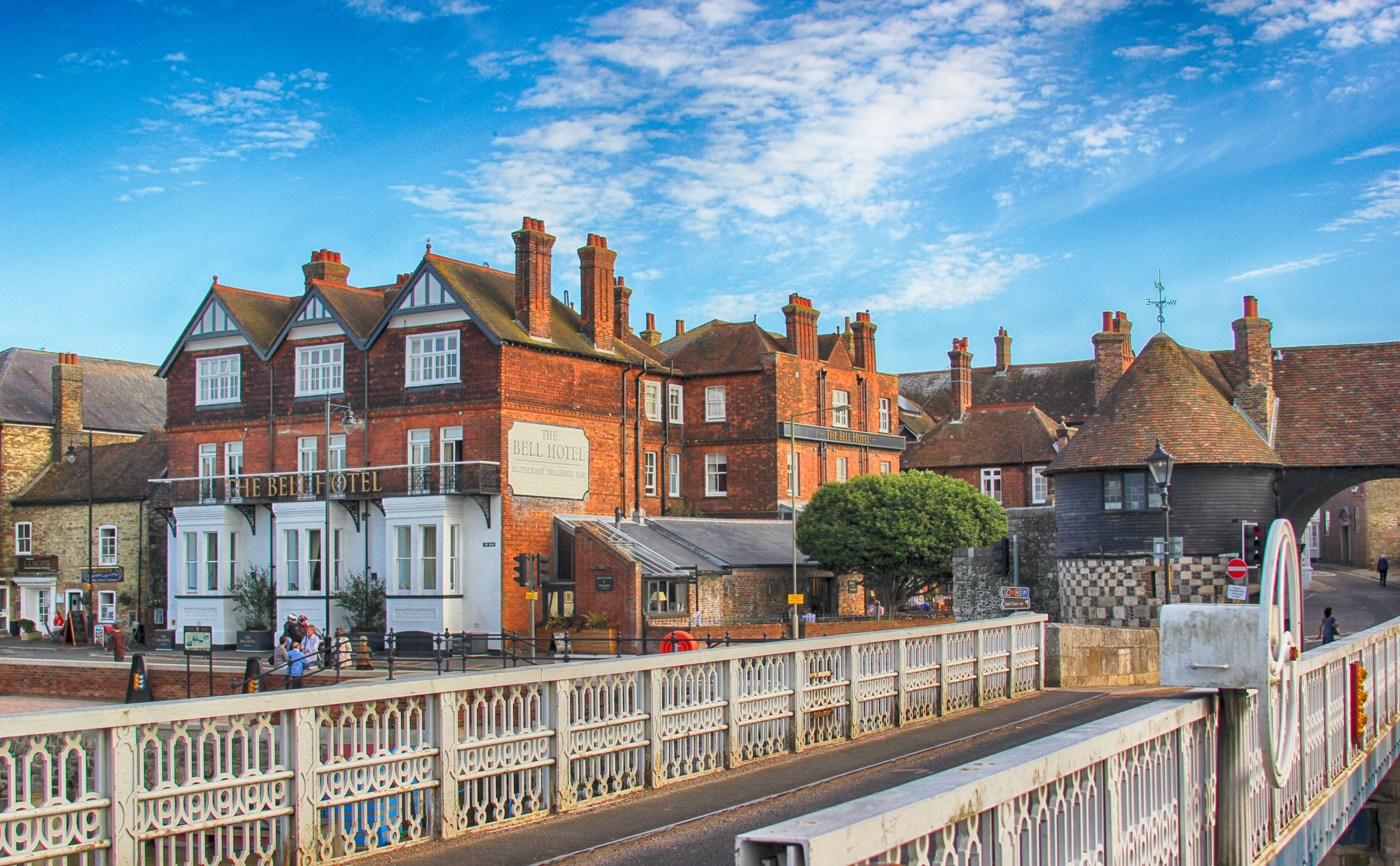 A metal bridge with a red brick building in the background