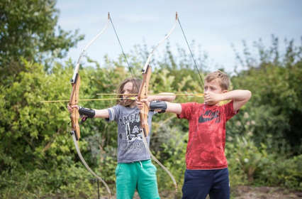 Two children doing archery target practice