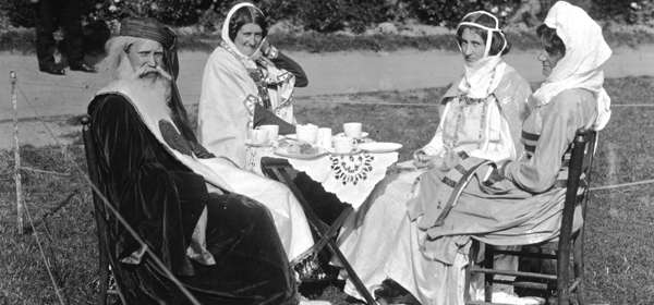 Black and white archive photo from a past Dover Pageant - four people in period costume sitting down to tea