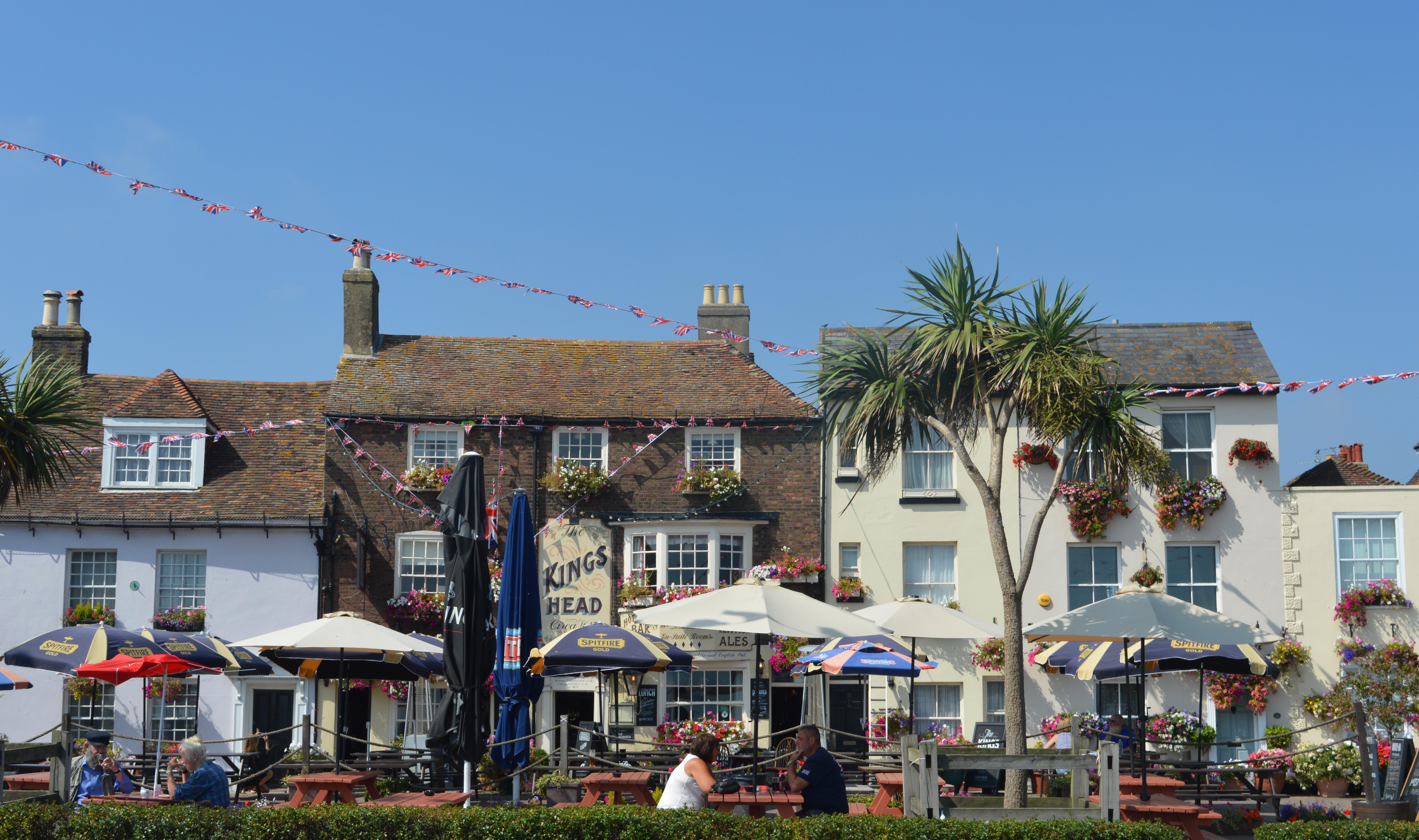 People sitting at tables outside Kings Head pub on Deal Seafront 