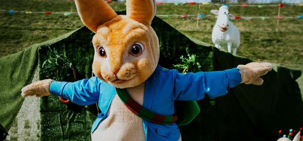 Human-sized Peter Rabbit character with sheep and carrots