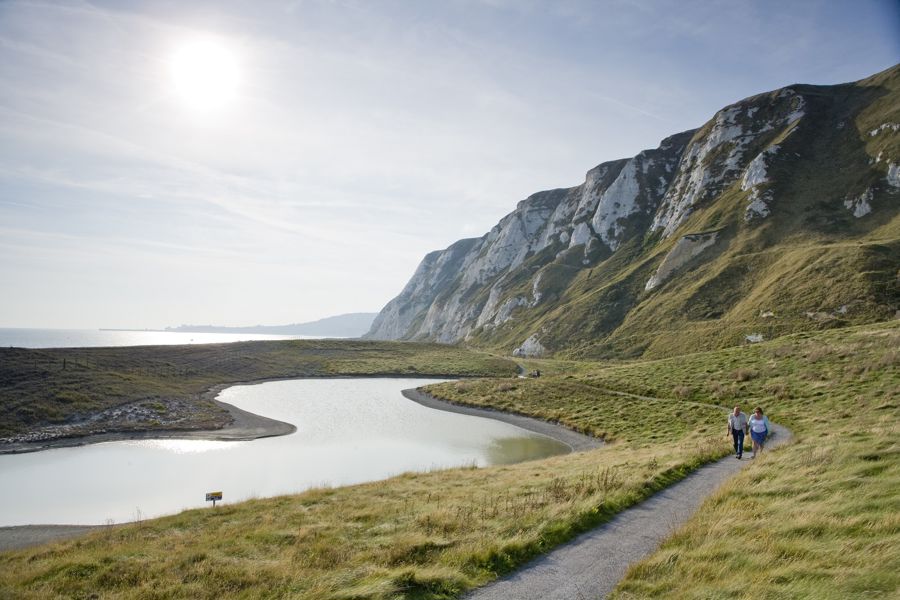 Couple walking on footpath, below cliffs at Samphire Hoe