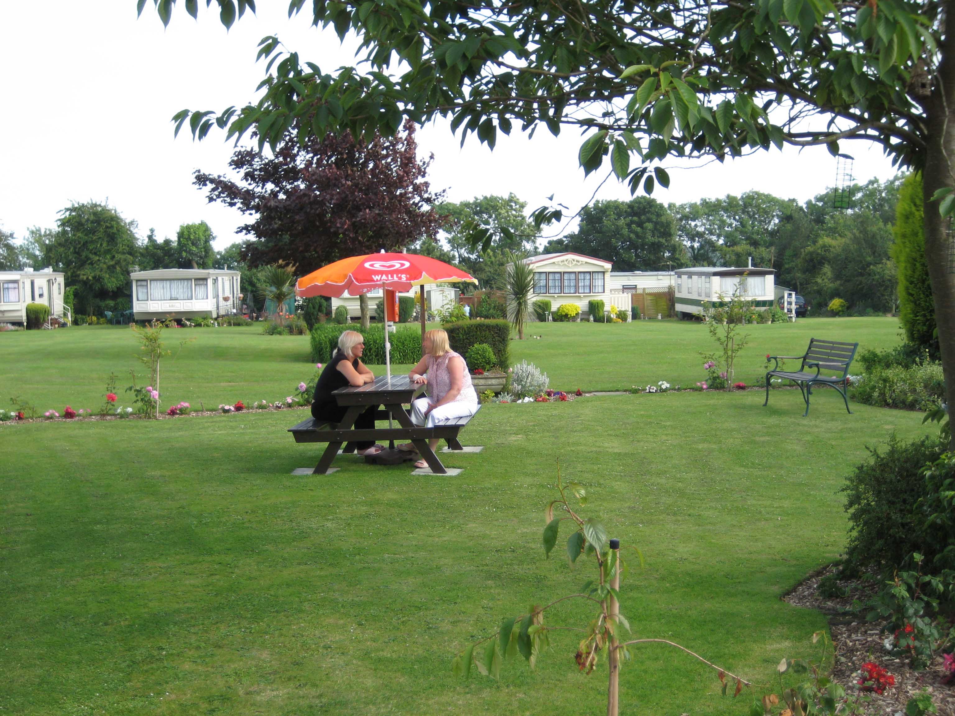 Little Satmar Holiday Park, Capel-le-Ferne, Dover, Kent, People on a picnic bench