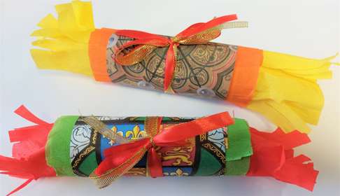 Two brightly coloured Christmas crackers with Maison Dieu inspired patterns