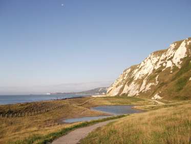 Green grass, blue sky and white cliffs