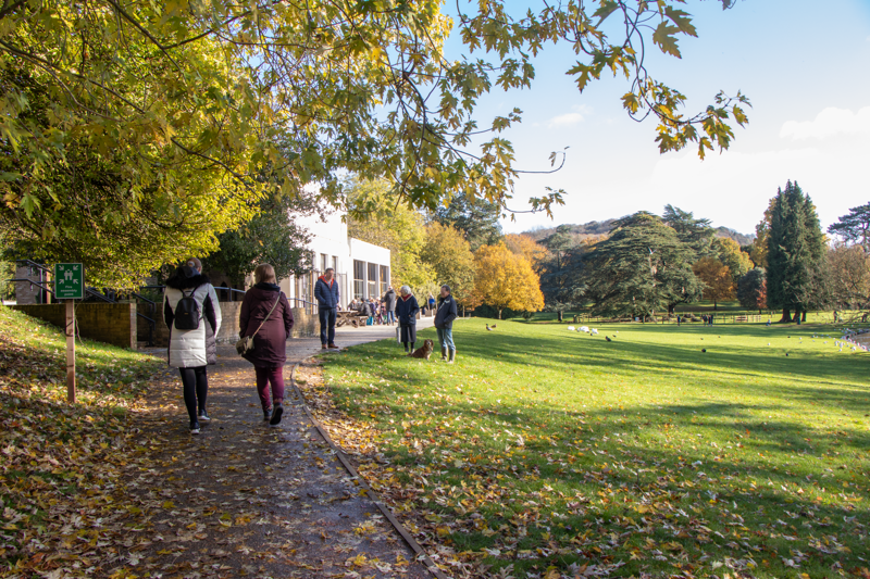 People walking in an autumn scene with a white building