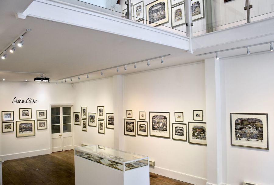 Studio space with white walls and black and white artwork hung on the walls.