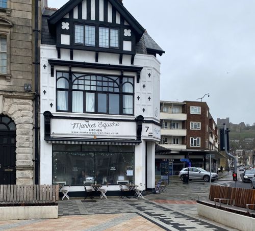 Black and white exterior of Market Square Kitchen in Dover with the castle in the background