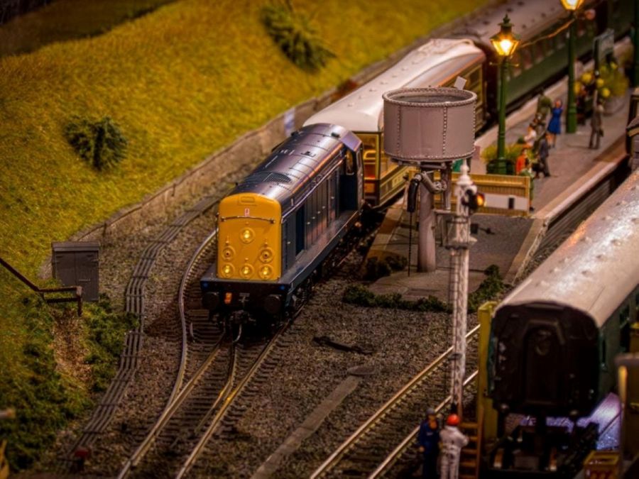 Model railway featuring a train leaving a station