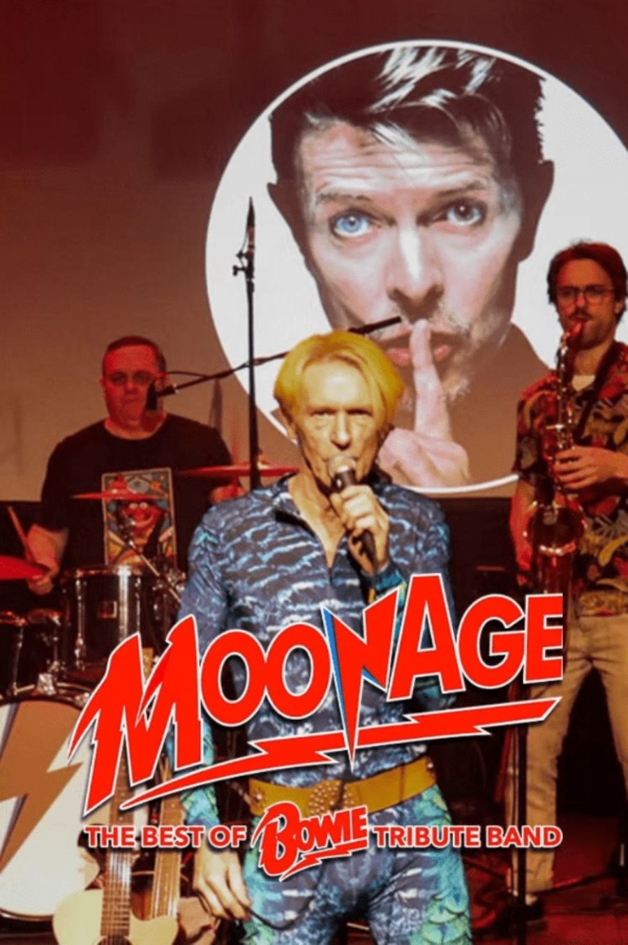 A blond haired male musician singing on stage with a photo of David Bowie behind him, and the words Moonage in red.