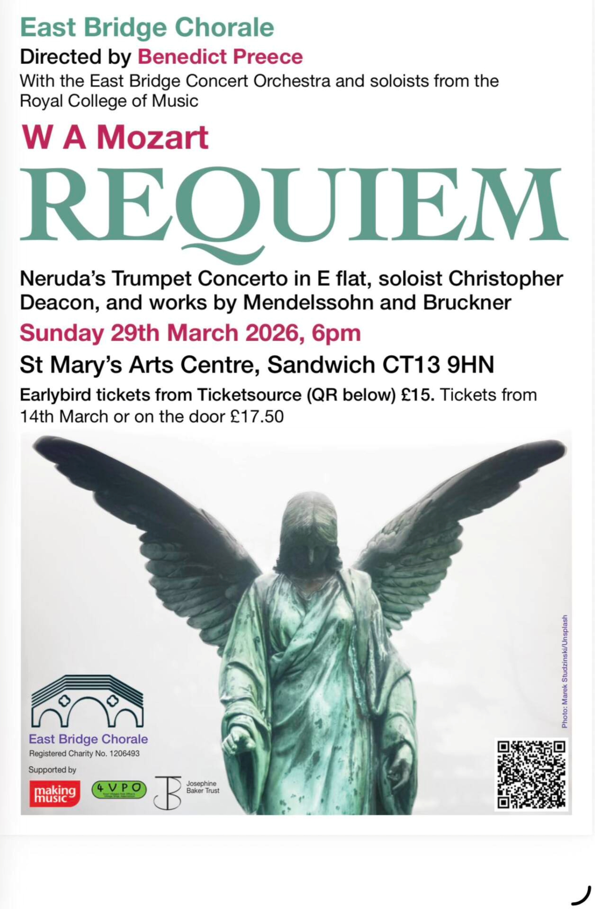 A statue of a greenish coloured angel with head bowed.