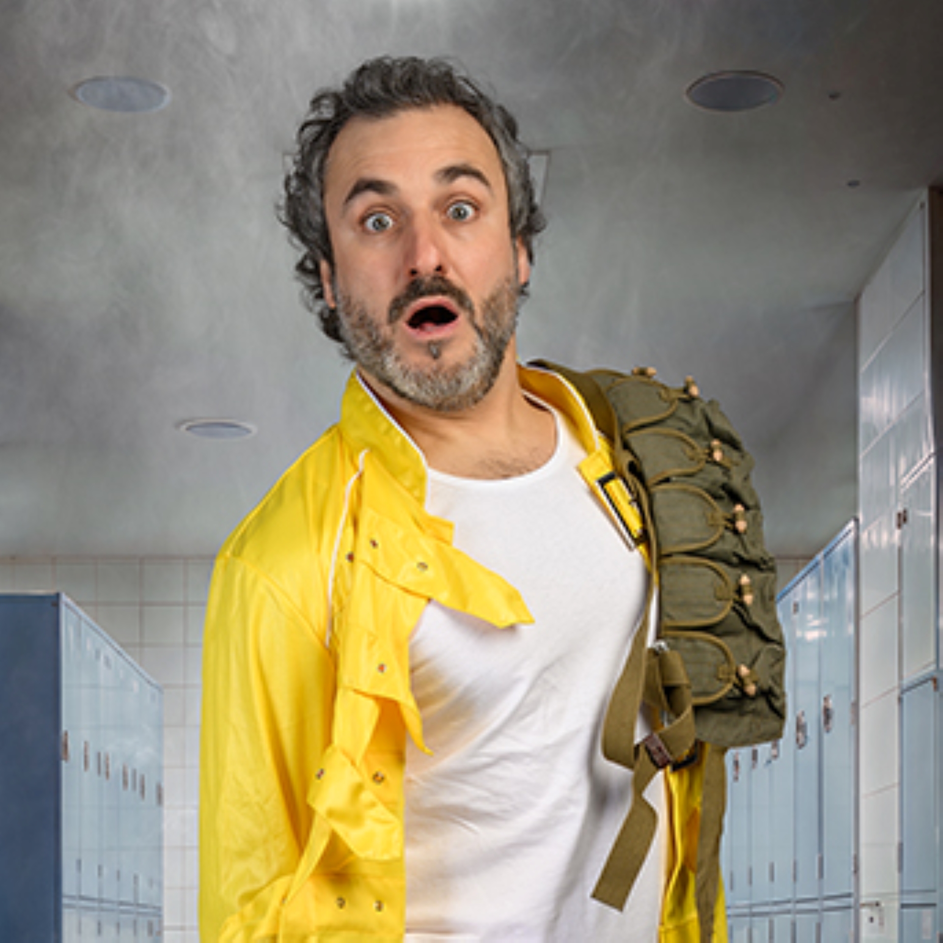 Patrick wearing a yellow jacket over a white t shirt with ammo slung over his shoulder