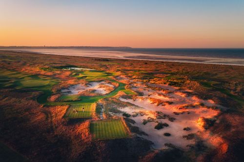 A golf course with dunes at sunrise