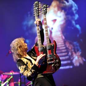 Image of a man playing a 2 neck guitar