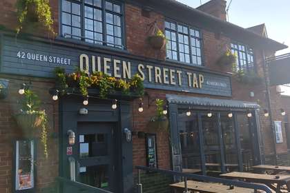 Exterior of the Queen Street Tap pub with hanging baskets
