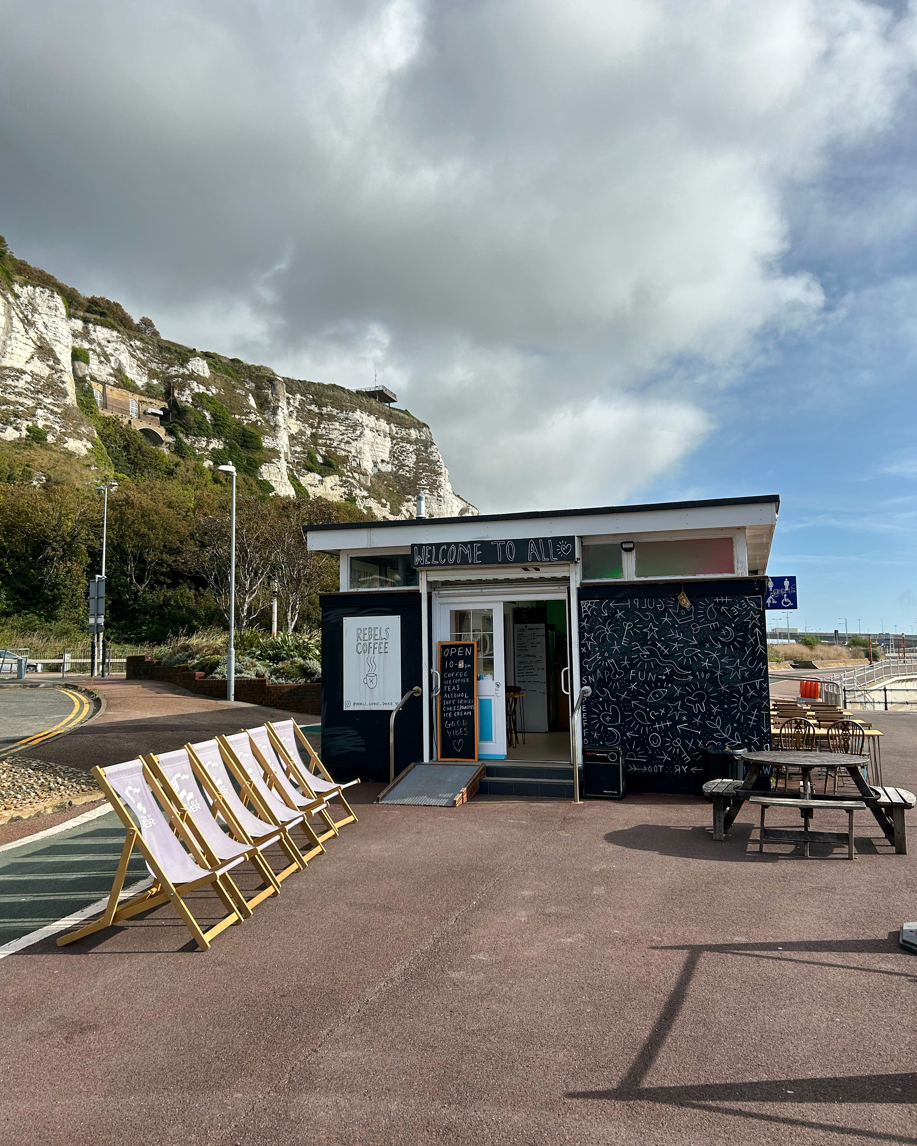 Outside view of Rebels Dover with deck chairs and the white cliffs in the background.