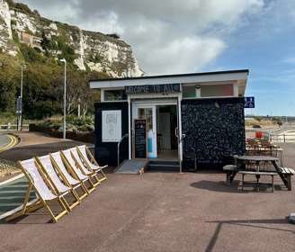 Outside view of Rebels Dover with deck chairs and the white cliffs in the background.