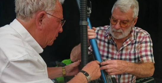 Two men repairing an item.