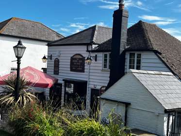 Exterior whitewashed boards of The Rising Sun pub