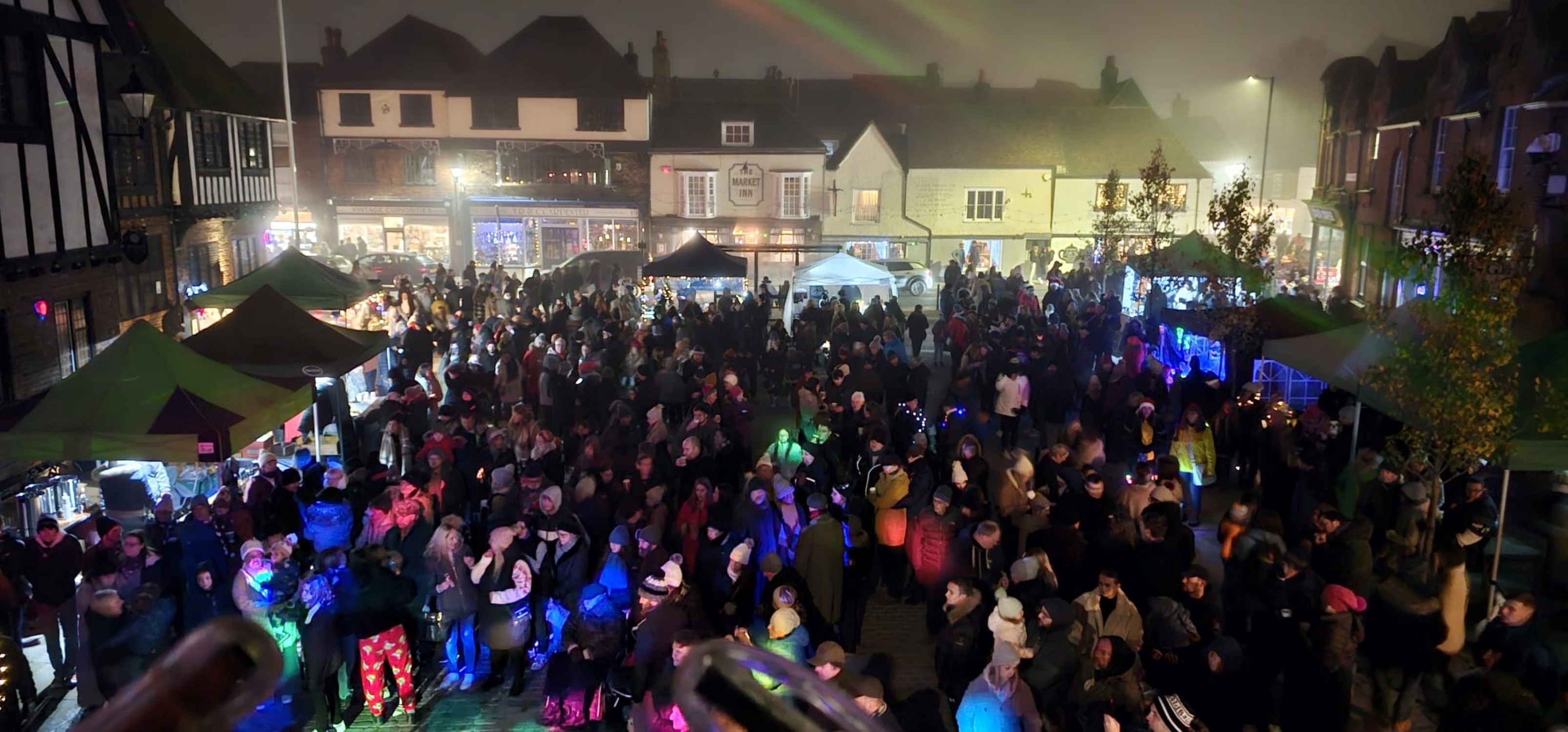 A crowd of people in winter with Christmas lights
