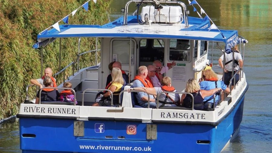 Blue and white boat with people wearing life jackets