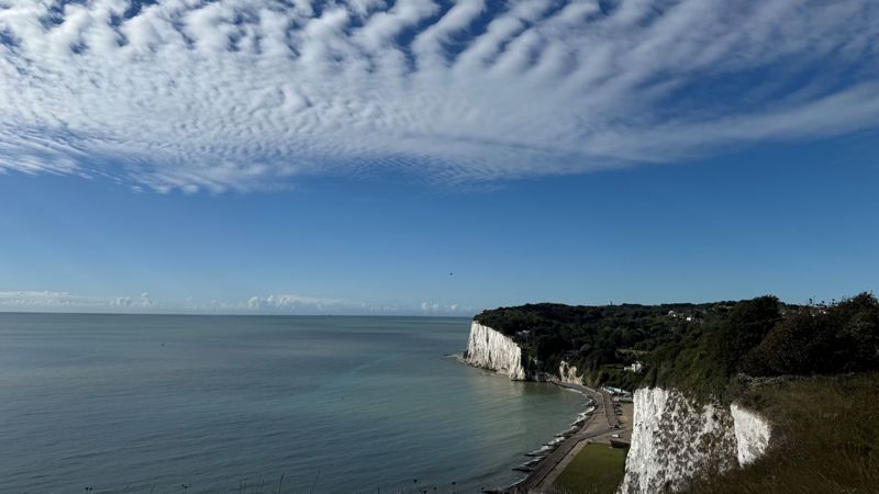 Blue sky with striped clouds over the sea and white cliffs