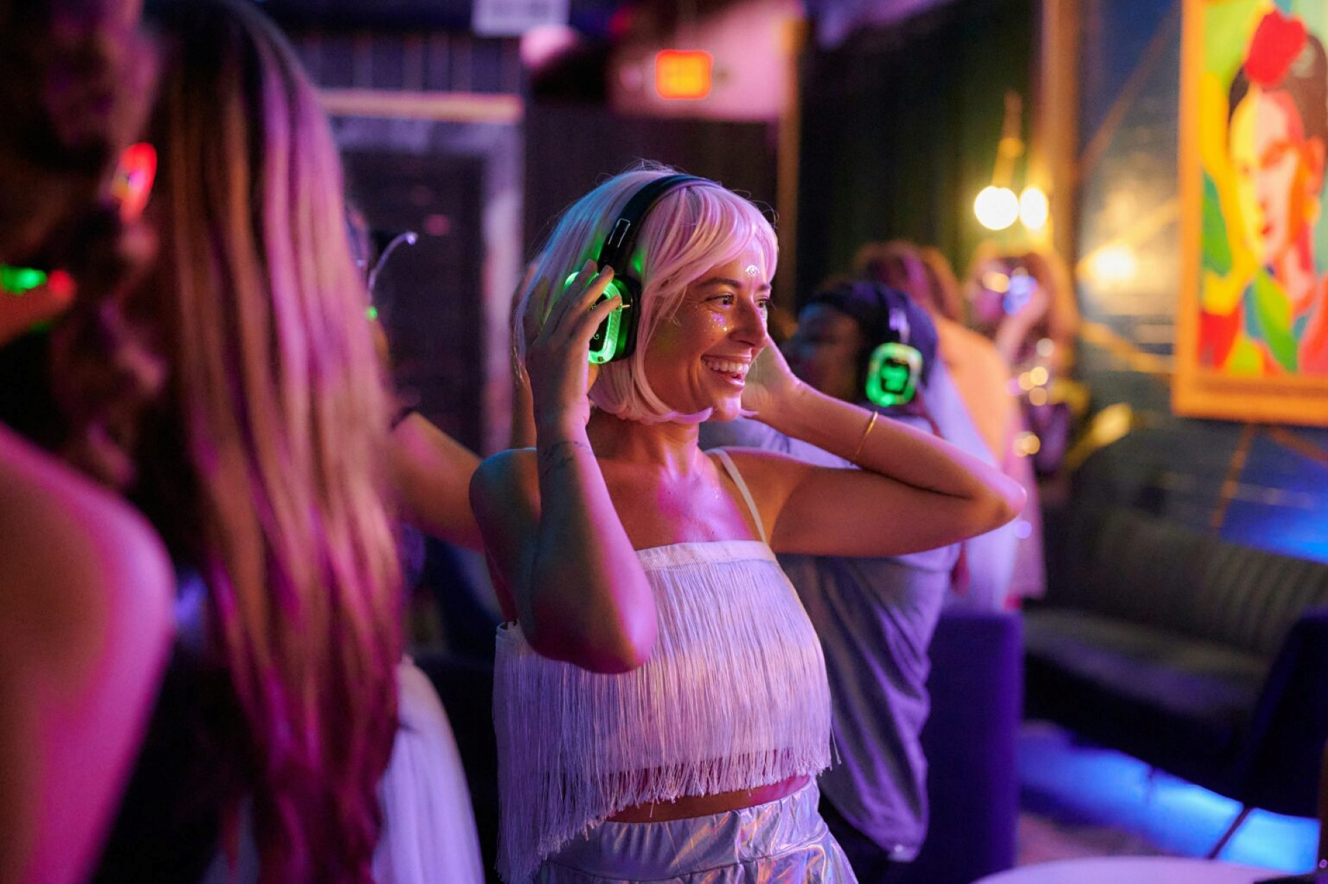 A lady in a white dress wearing headphones