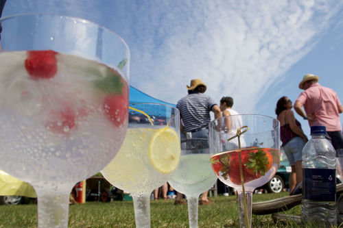 A selection of drinks with people in the background and blue sky.