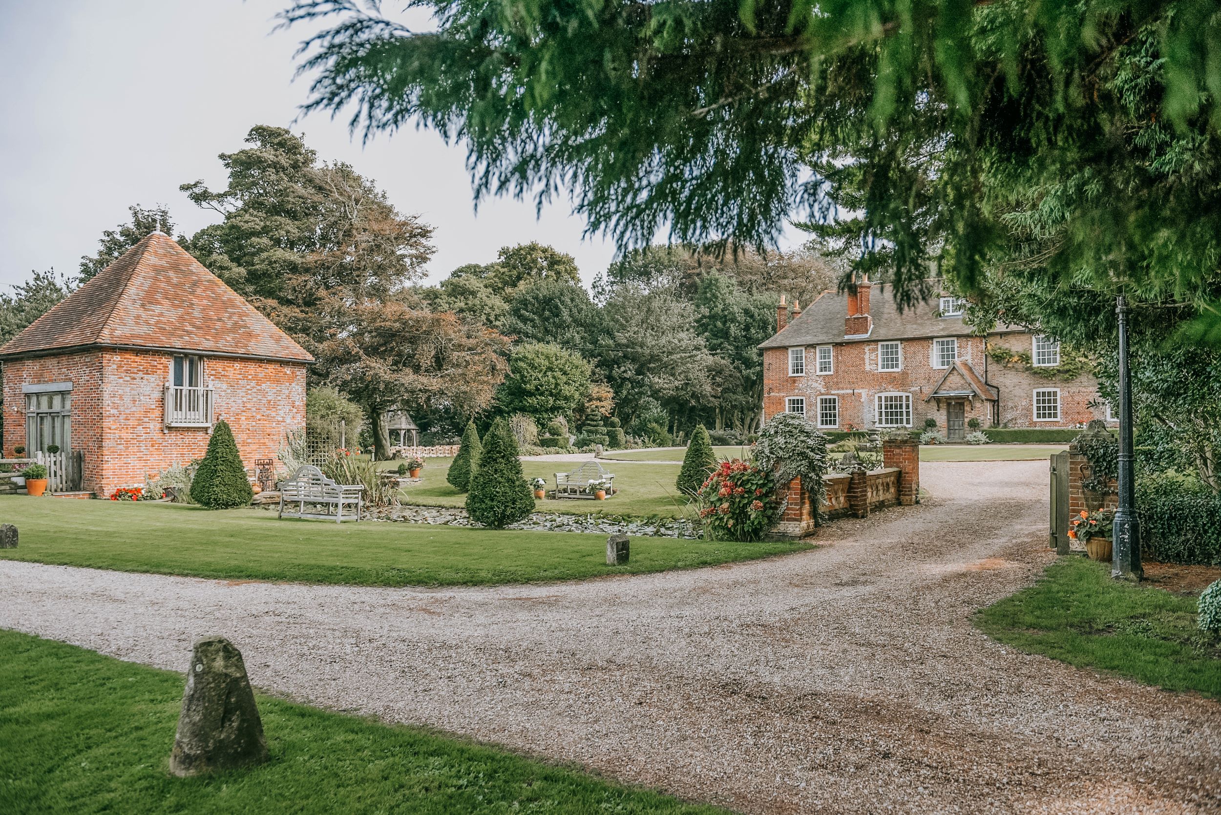 Red brick manor house surrounded by gardens