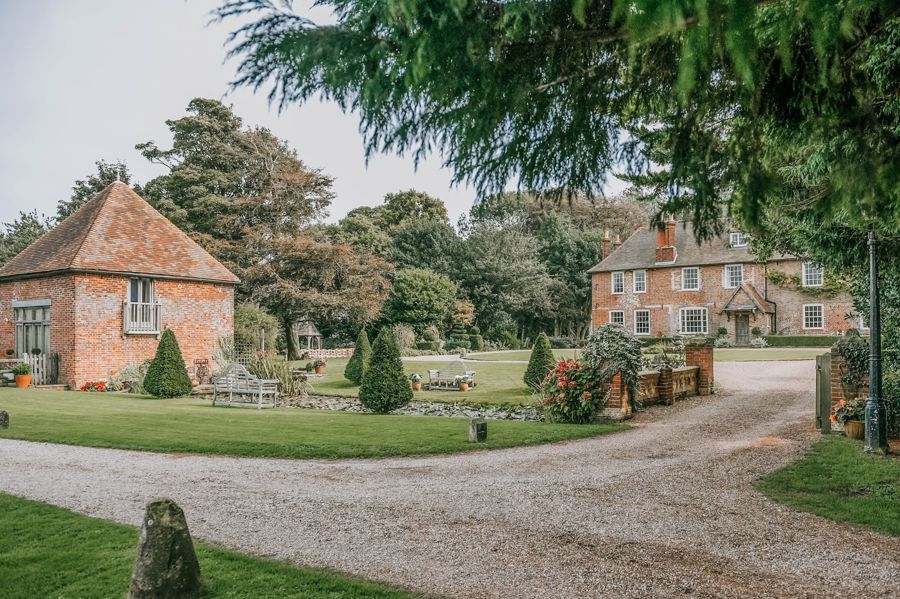 Two red brick buildings set in beautiful grounds