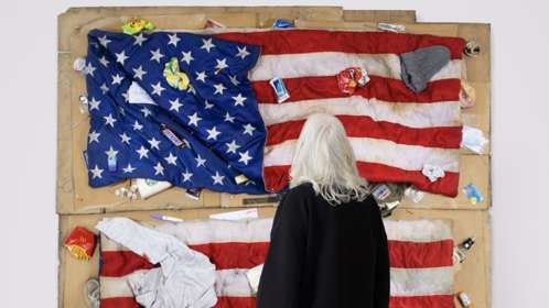 A woman with her back to camera views a large scale conceptual art piece