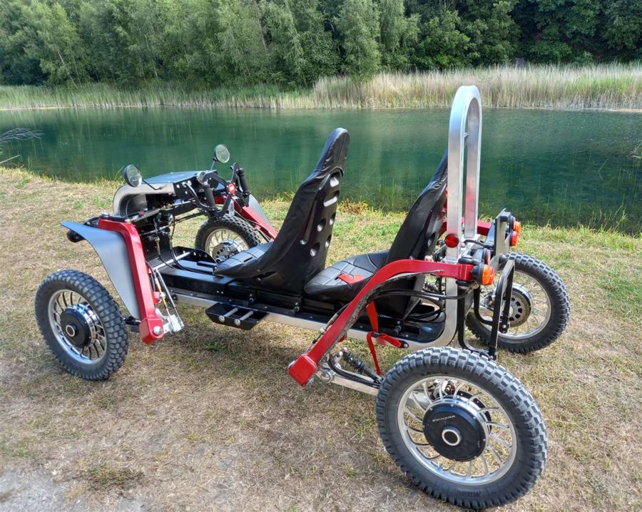 An open-sided electric vehicle parked next to a lake