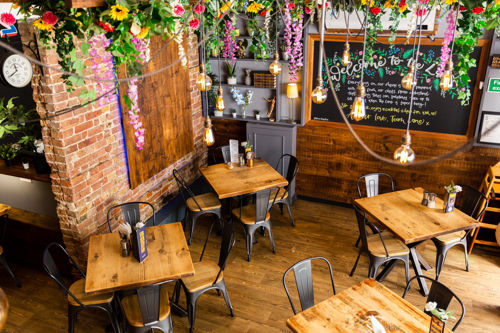 Looking down on the cafe space with wooden tables and chairs.