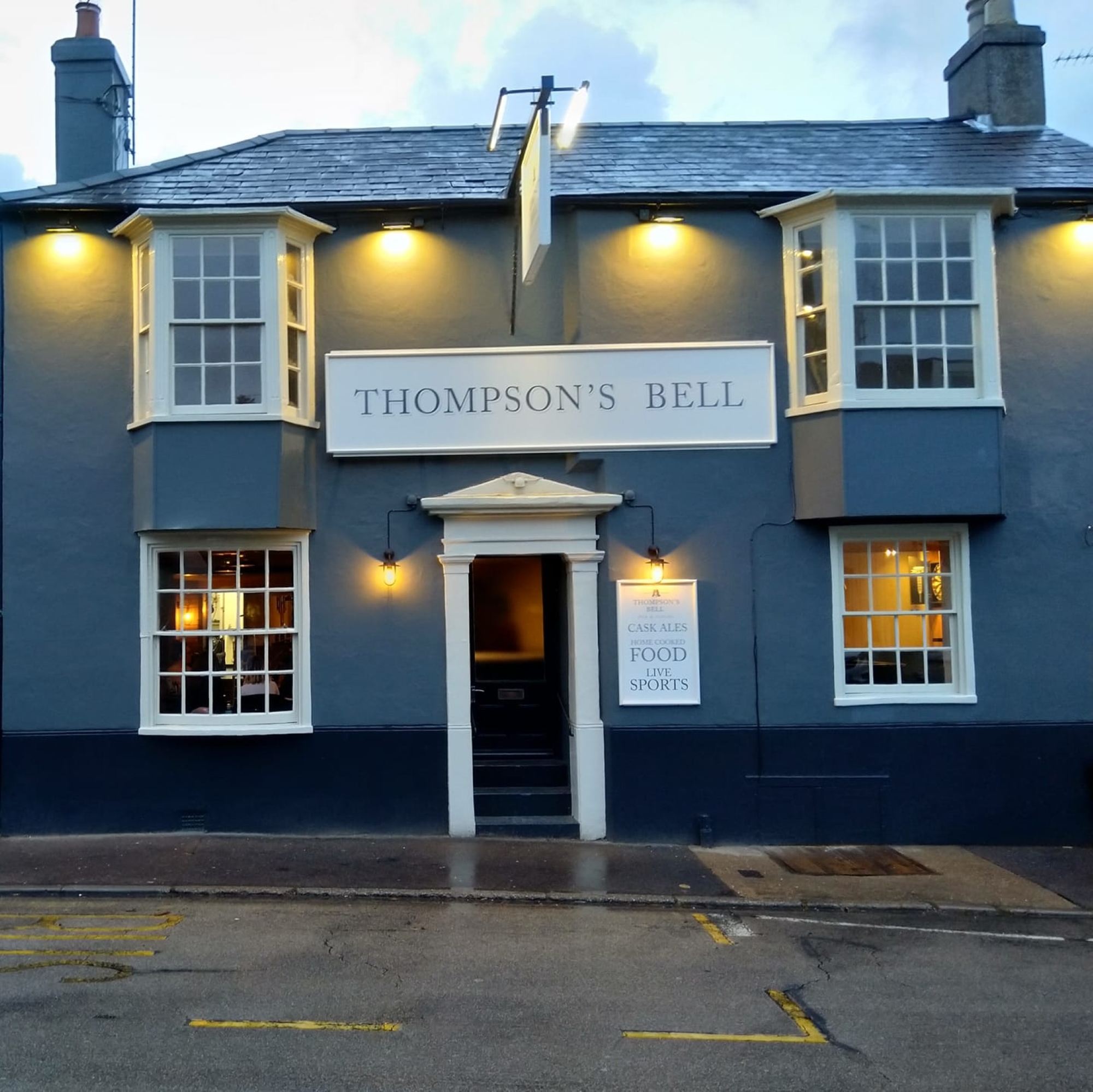 Front view of a blue painted pub called Thompsons Bell