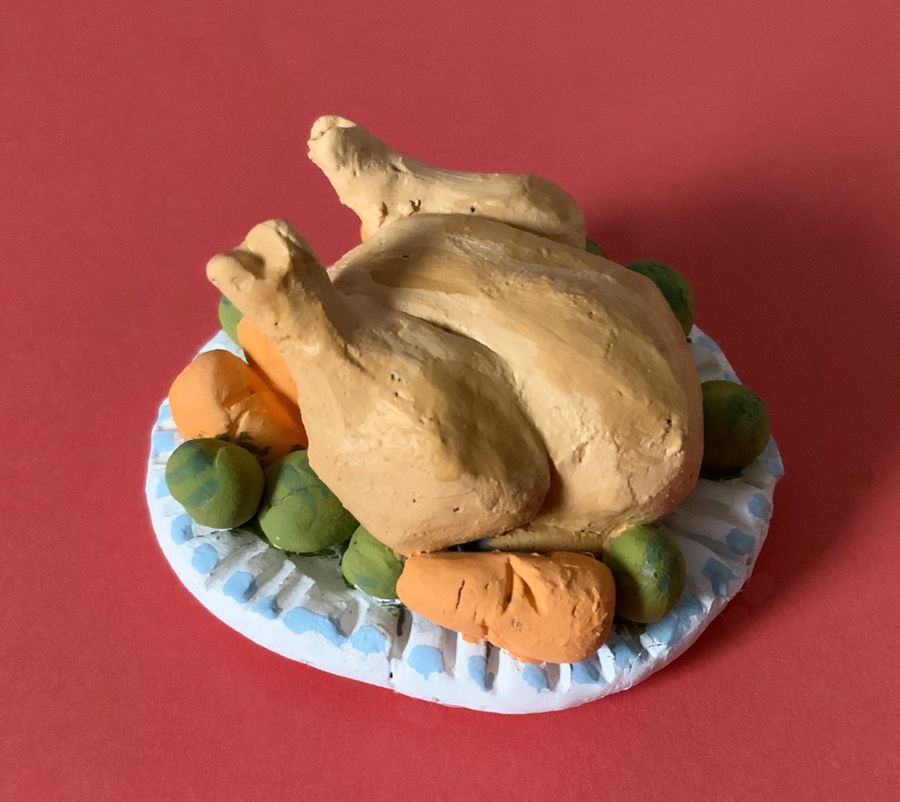 A miniatiure dinner plate of turket, carrots and peas, made from painted clay