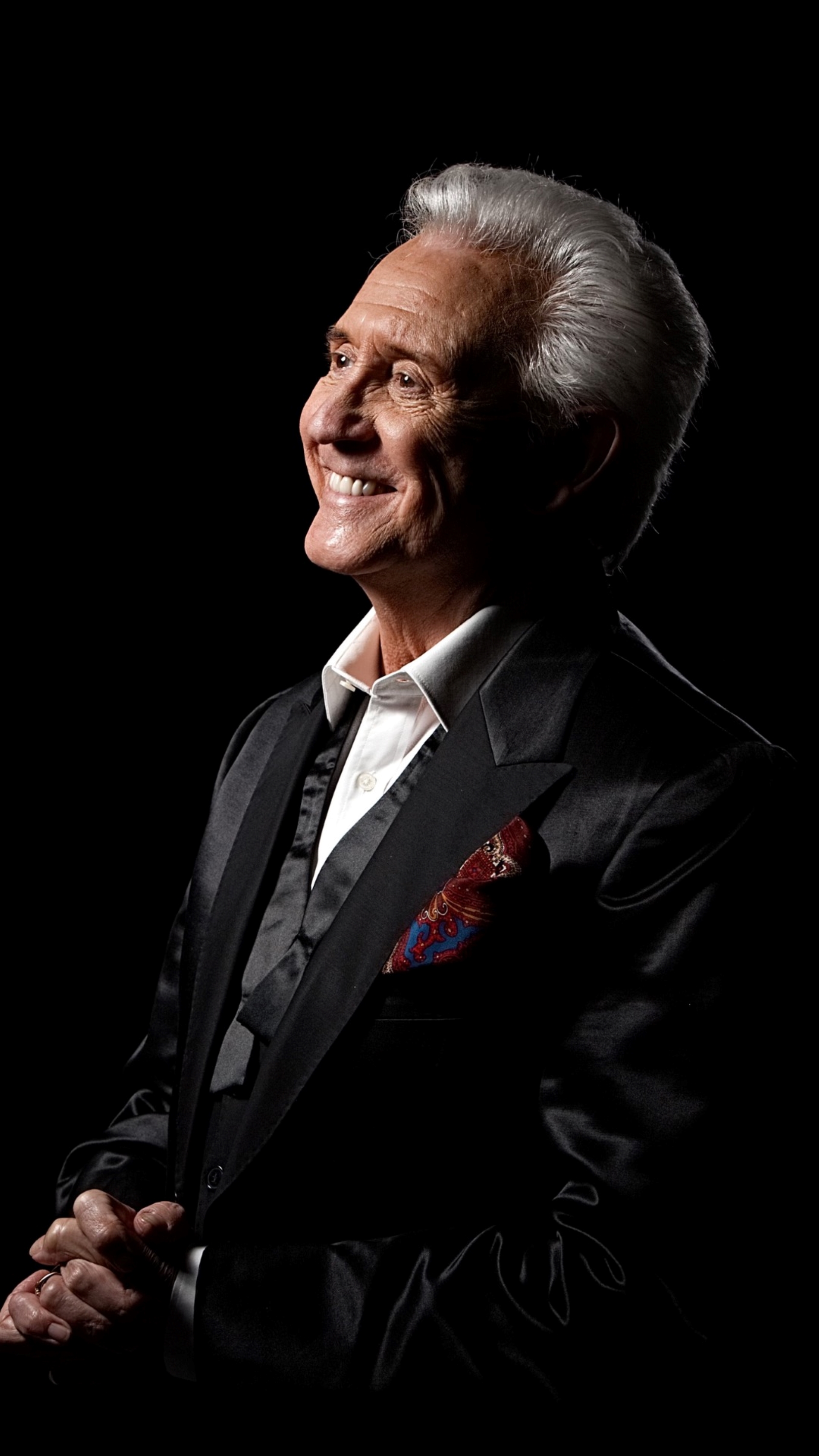 Side view of head and shoulders of Tony smiling in black tux