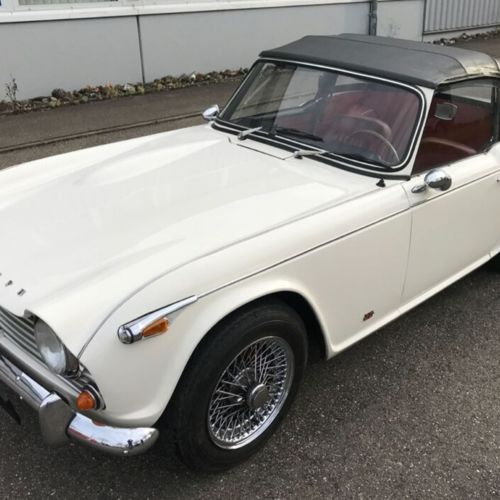 Image of white Triumph TR4 with soft top up