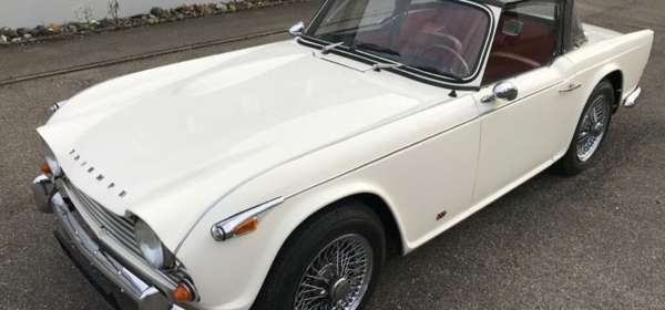 Image of white Triumph TR4 with soft top up